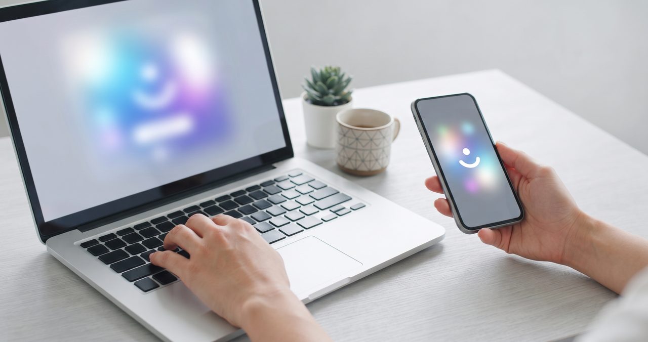 ノートパソコンとスマートフォンを両方使いながら作業する人の手元、画面には文字は表示されていない様子